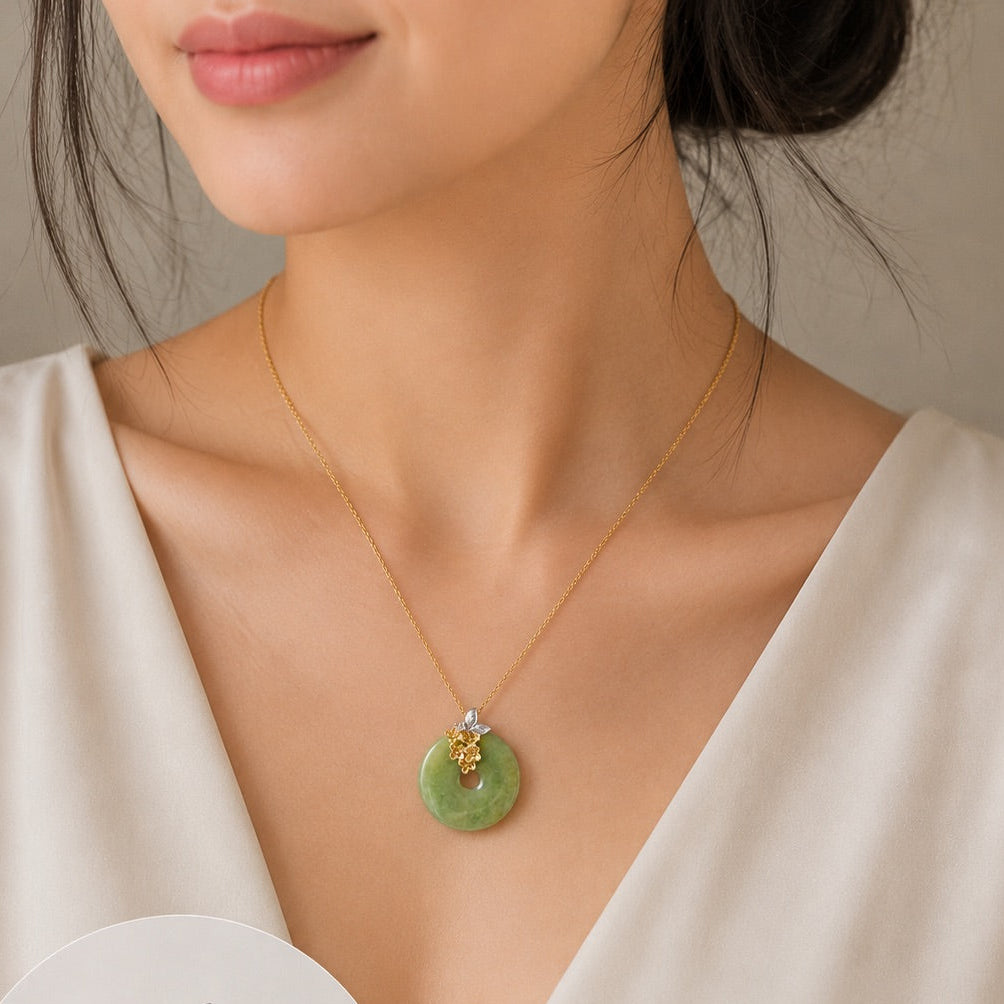 A woman wearing a delicate gold necklace with a green jadeite pendant shaped like an osmanthus flower. The image includes a circular inset showing the pendant's dimensions (21.