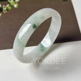 Floral jadeite bangle bangle displayed on a white surface with a dark brown background. The brand name 'YOKDEE JEWELLERY' is overlaid at the bottom.